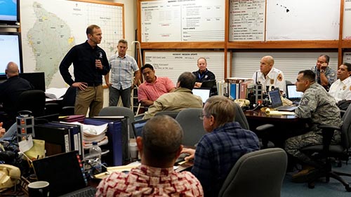 A FEMA task force convenes in a meeting room with white boards in Hawaii