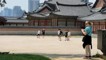 HS-POWER Intern Brook Cochran (in green shirt), looking out at a group of children during a visit to Gyeongbokgung Palace in Seoul.