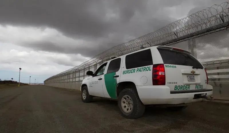 Border Patrol vehicle next to a fence